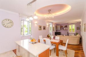 a kitchen and living room with a table and a clock at Apartment Djivo in Dubrovnik