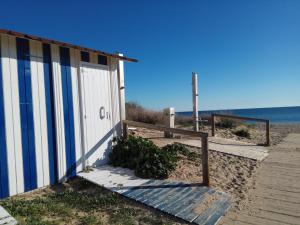 a building on the beach next to the ocean at islantilla adosado piscina parking 1 minuto al mar in Islantilla