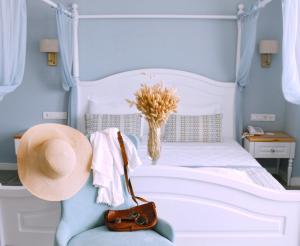 een slaapkamer met een wit bed met een hoed op een stoel bij Luvi Kaş Otel - Adults Only (+16) in Kas