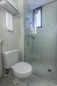 a white toilet sitting next to a shower in a bathroom at Mercure Sao Paulo Naçoes Unidas in São Paulo