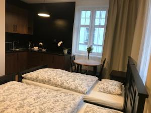 two beds in a room with a table and a window at Belgard- House 32 in Białogard