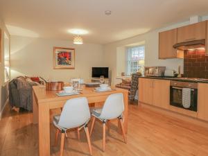 a kitchen and living room with a table and chairs at Tartan in Golspie