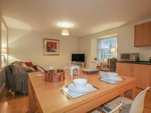 a living room with a wooden table with dishes on it at Tartan in Golspie