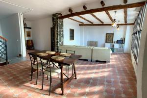 sala de estar con mesa, sillas y sofá en Villa Loza Dorada, en Lanjarón