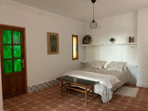 a bedroom with a bed and a table in it at Villa Loza Dorada in Lanjarón