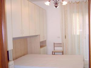 1 dormitorio con 1 cama y 1 silla junto a una ventana en Grottammare mon amour Pineta en Grottammare