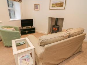 a living room with a couch and a fireplace at The Little Bower in Hawes