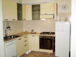 a kitchen with white cabinets and a sink and a refrigerator at Grottammare mon amour Pineta in Grottammare