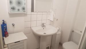 een witte badkamer met een wastafel en een toilet bij Appart entier 1 ch à ch-gontier 1er ou 2eme étage in Château-Gontier