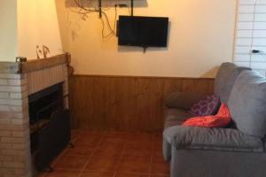 a living room with a couch and a flat screen tv at LA CASITA VERDE in Onís
