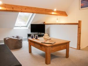 a living room with a coffee table and a tv at The Hayloft in Oswestry