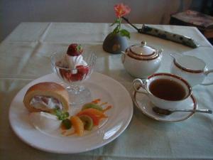 Una mesa con un plato de comida y una taza de café. en Earl Grey, en Hakuba