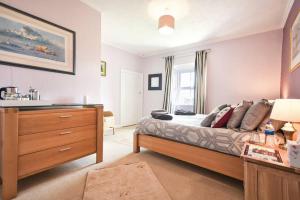 a bedroom with a bed and a dresser in it at Rocking Chair Farmhouse in Alnwick
