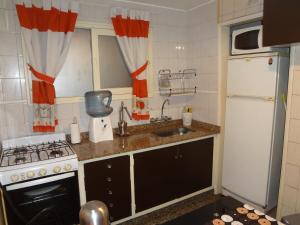 a kitchen with a sink and a stove and a refrigerator at Depto en Parque Central in Mendoza