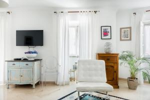 een witte woonkamer met een stoel en een tv bij Soul of Lisbon - V in Lissabon