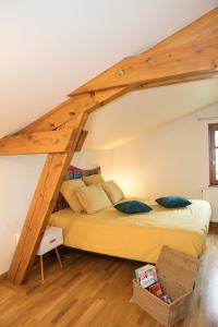 ein Schlafzimmer mit einem großen Bett im Dachgeschoss in der Unterkunft Halte champêtre et familiale à 5 min de Tournus in LʼAbergement-de-Cuisery