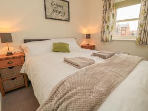 a bedroom with a bed with two pillows on it at Chestnut Cottage in Morpeth