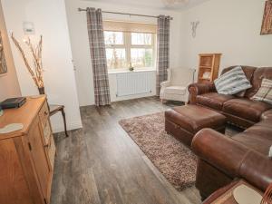 a living room with a couch and a chair at Chestnut Cottage in Morpeth