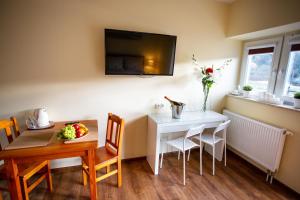 a dining room with a table and a white table and chairs at Rancho Ulinia koło Łeby in Ulinia