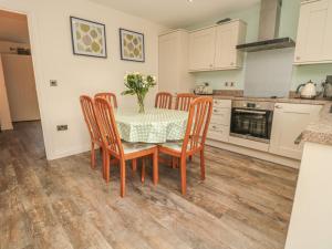 a kitchen with a table and chairs with a vase of flowers at Chestnut Cottage in Morpeth