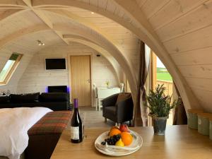 a room with a bottle of wine and a plate of fruit at Caithness View Luxury Farm Lodges and BBQ Huts in Wick