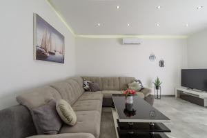 a living room with a couch and a tv at Apartmani MM in Trogir