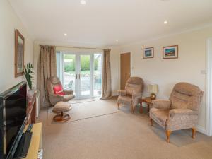 a living room with two chairs and a television at Little Lanes in Camelford