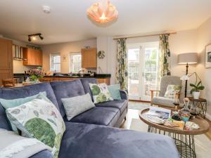 a living room with a blue couch and a table at Jenny's Cottage in Grange Over Sands