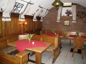 テュービンゲンにあるホテル バーバリーナの木製のテーブルと椅子、赤いテーブルのあるレストラン