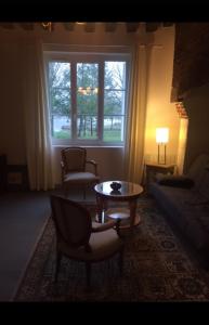 sala de estar con sofá, mesa y ventana en Auberge de villechaume, en Sennely