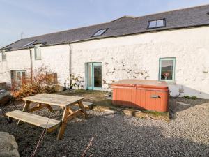 a picnic table and a chest in front of a building at Lintie Cottage in Dalbeattie