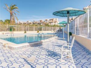 a patio with a chair and an umbrella next to a pool at Casa Pura Vida Guardamar del Segura in El Moncayo