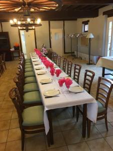 a long table with chairs and red roses on it at Auberge de villechaume in Sennely +13 photos