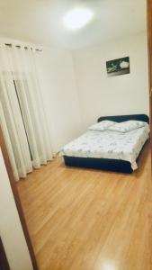 1 dormitorio con 1 cama y suelo de madera en Apartmani Niko, en Radovin