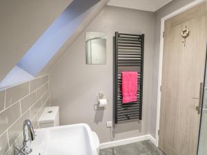 a bathroom with a sink and a towel rack at Little Wash Cottage in Hunstanton +35 photos