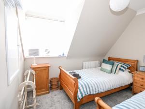 a small bedroom with a bed and a window at Little Wash Cottage in Hunstanton