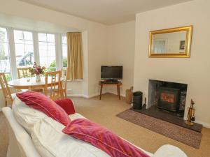 a living room with a white couch and a fireplace at Corner Cottage in Beaumaris