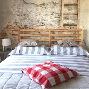 a bed with two pillows and a brick wall at Marea Apartamenty Ustka in Ustka