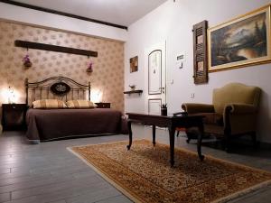 a bedroom with a bed and a desk and a chair at Ξενώνας Γούσιας in Ioannina