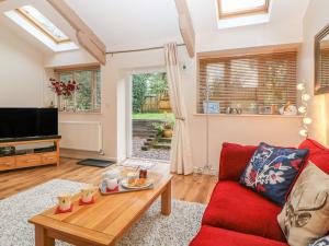 a living room with a red couch and a table at Tregona in Yelverton