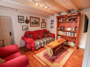 a living room with a red couch and a table at Mary Rose Cottage in Castleisland