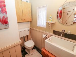 Mary Rose Cottage في جزيرة القلعة: حمام مع حوض ومرحاض ومرآة +28 صورة