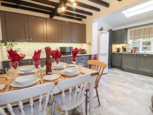 a kitchen with a wooden table with red napkins at Pool Cottage in Lincoln