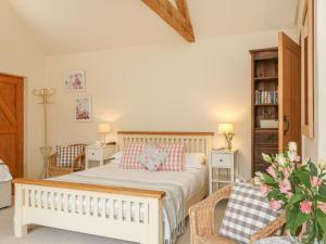 a bedroom with a bed and a book shelf at The Apple Barn at Wyke Farm in Axminster