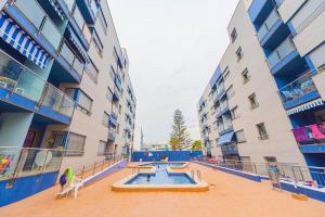 una piscina al centro di un edificio con due edifici di Los Locos Beach Apartments a Torrevieja