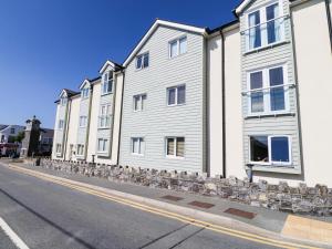 une rangée de bâtiments blancs sur le côté d'une rue dans l'établissement 10 Pen Llanw Tides Reach, à Rhosneigr