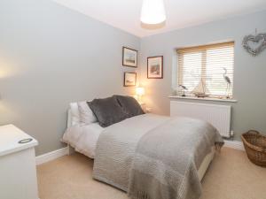 a bedroom with a bed and a window at 10 Pen Llanw Tides Reach in Rhosneigr