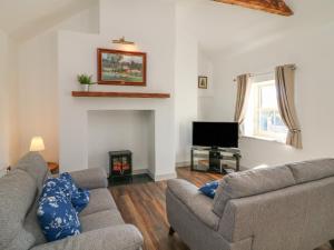 a living room with two couches and a fireplace at Macreddin Rock Holiday Cottage in Aughrim