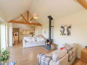 a living room with two couches and a fireplace at The Shippon in Axminster