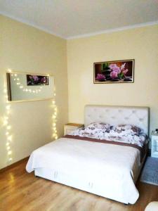 a bedroom with a bed with lights on the wall at "ELITE" in the Center near the Theater in Chernivtsi